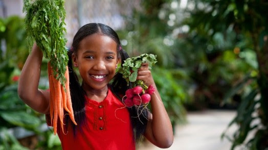 Image of child holding vegetables