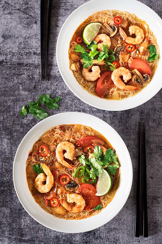 Soups with shrimp, vegetables, and a lime.