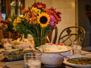 Meal on table with an assortment of flowers in the middle.