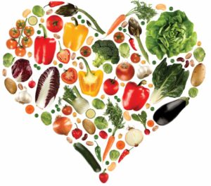 Vegetables and fruits arranged in the shape of a heart.