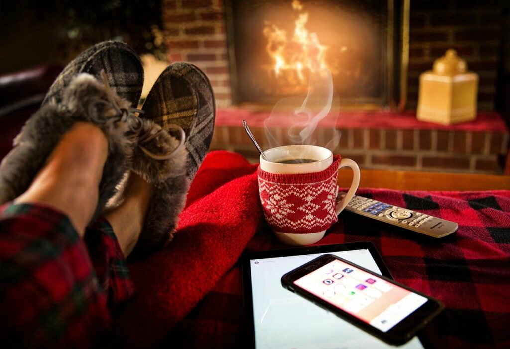 feet with slippers on, propped on ottoman with coffee or tea