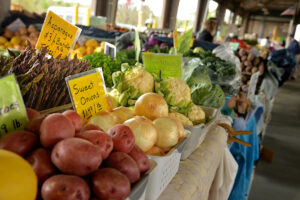Farmer's market stand with produce and signs