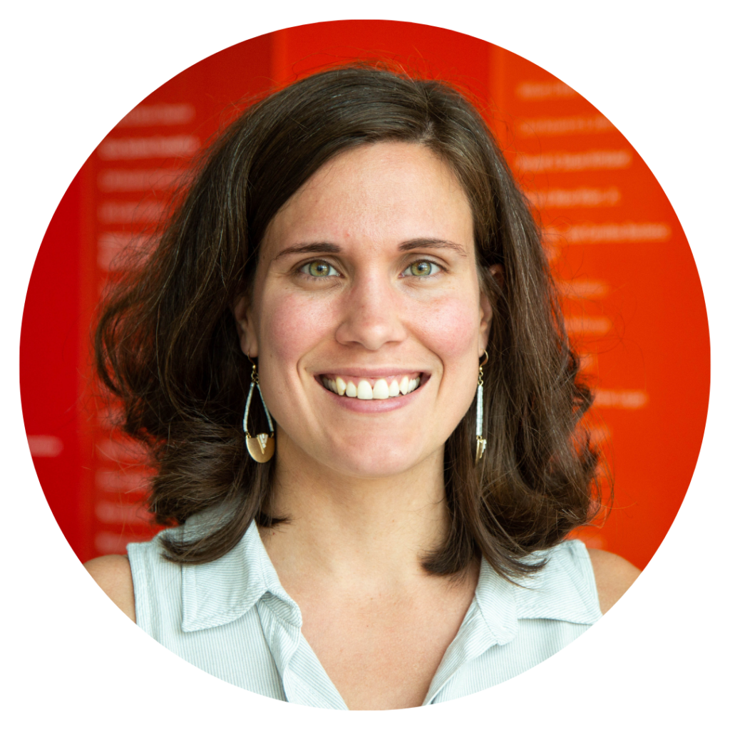 A woman smiling in front of a red background.